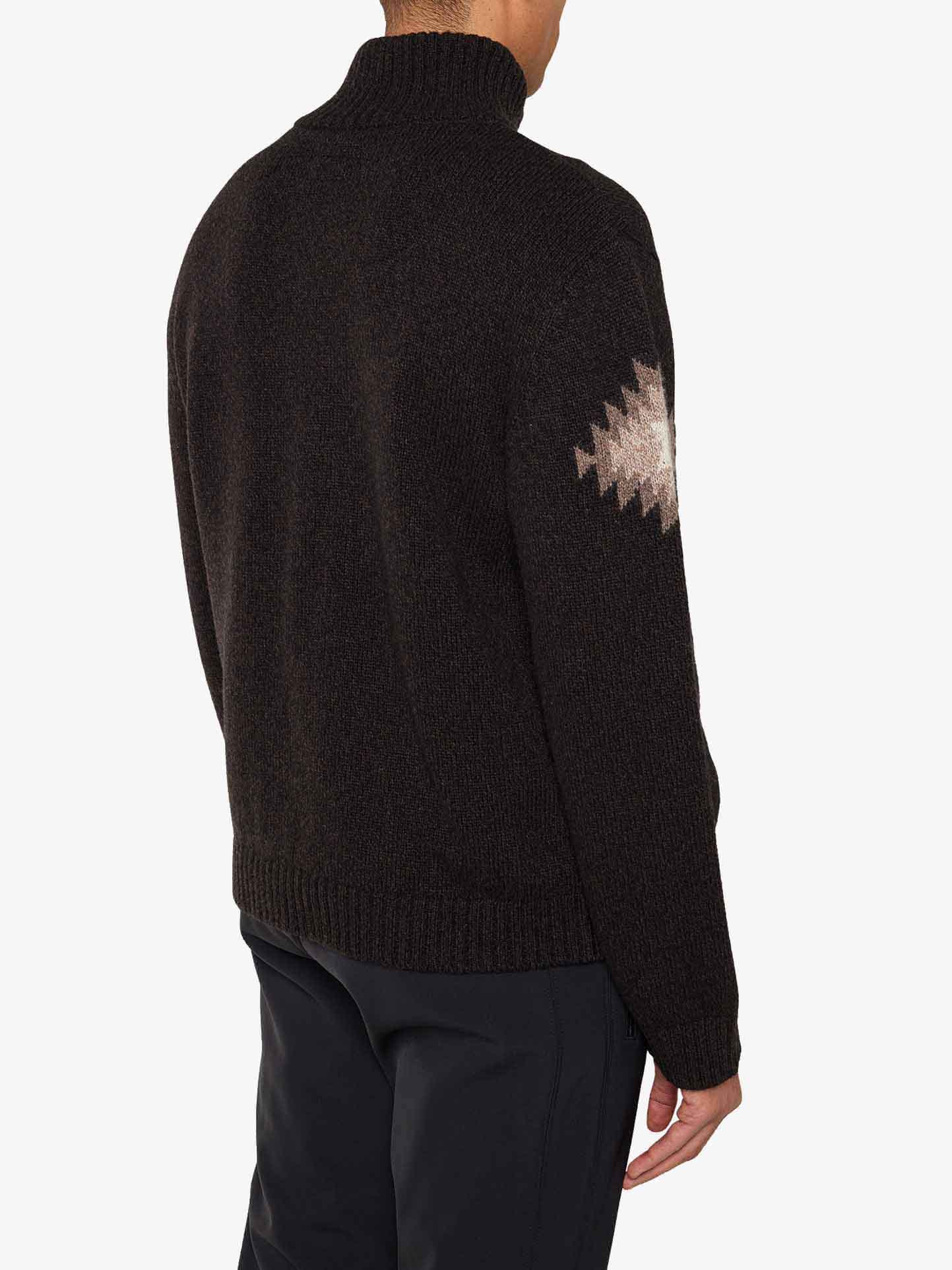 We Norwegians_FW25_Men | Model is wearing the Hovden sweater | Black in color with a striking jacquard pattern inspired by the Norwegian Sámi culture | Back view against a white background