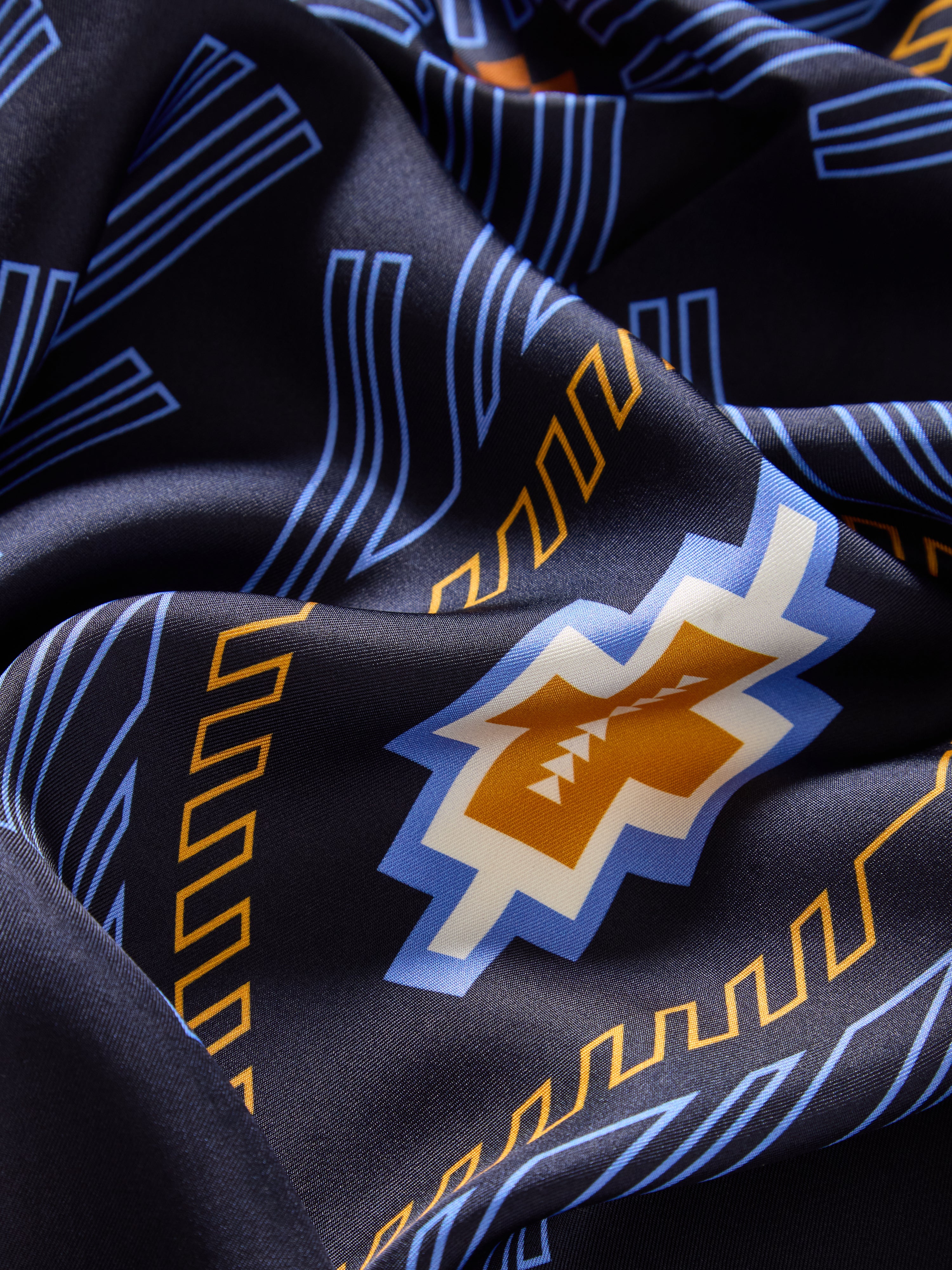 We Norwegians | FW25 | Pioneer Silk Scarf_Navy blue | Scarf with printed motifs inspired by Indigenous American art | Photograph showing the fabric and print details