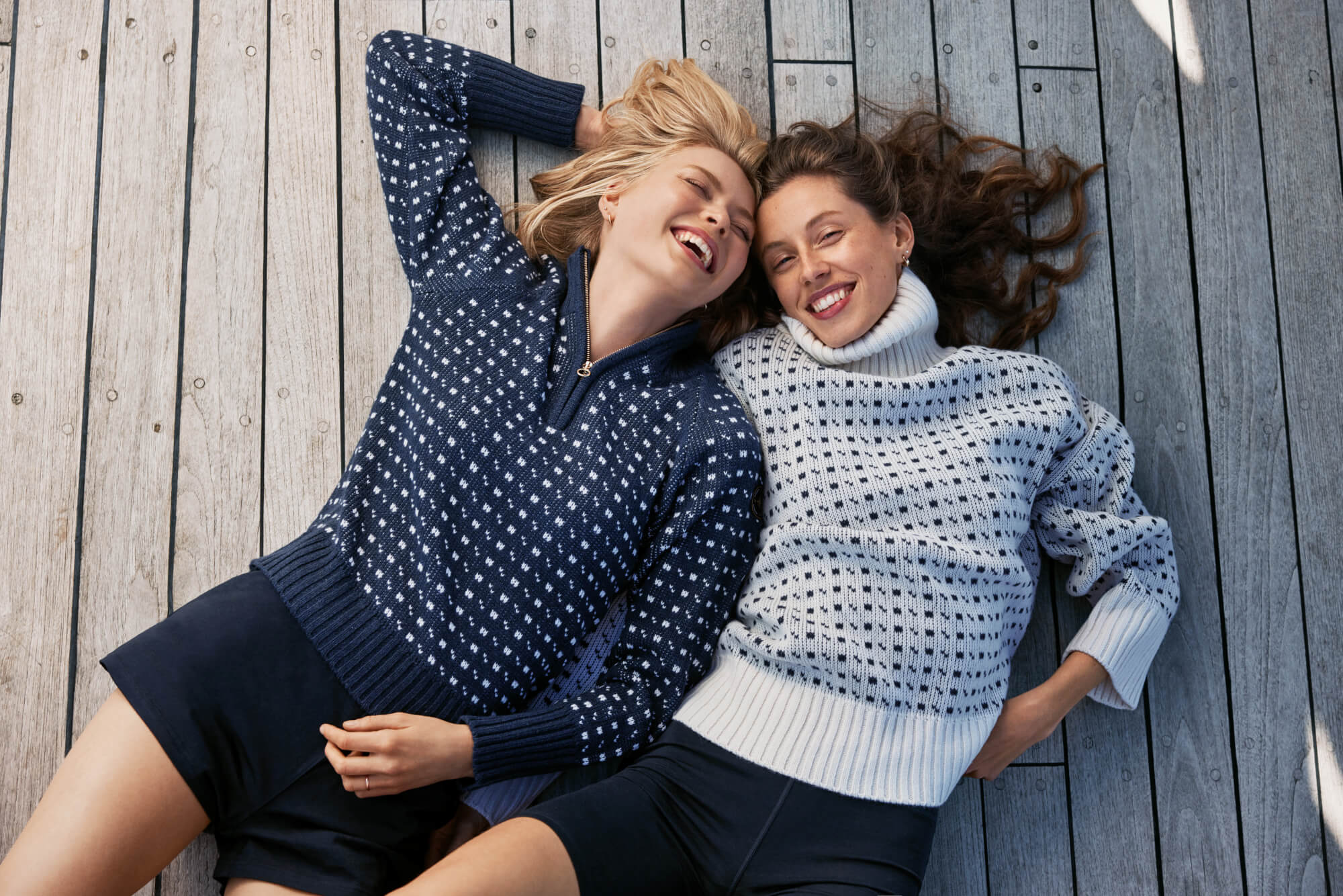 Two women laying on deck smiling
