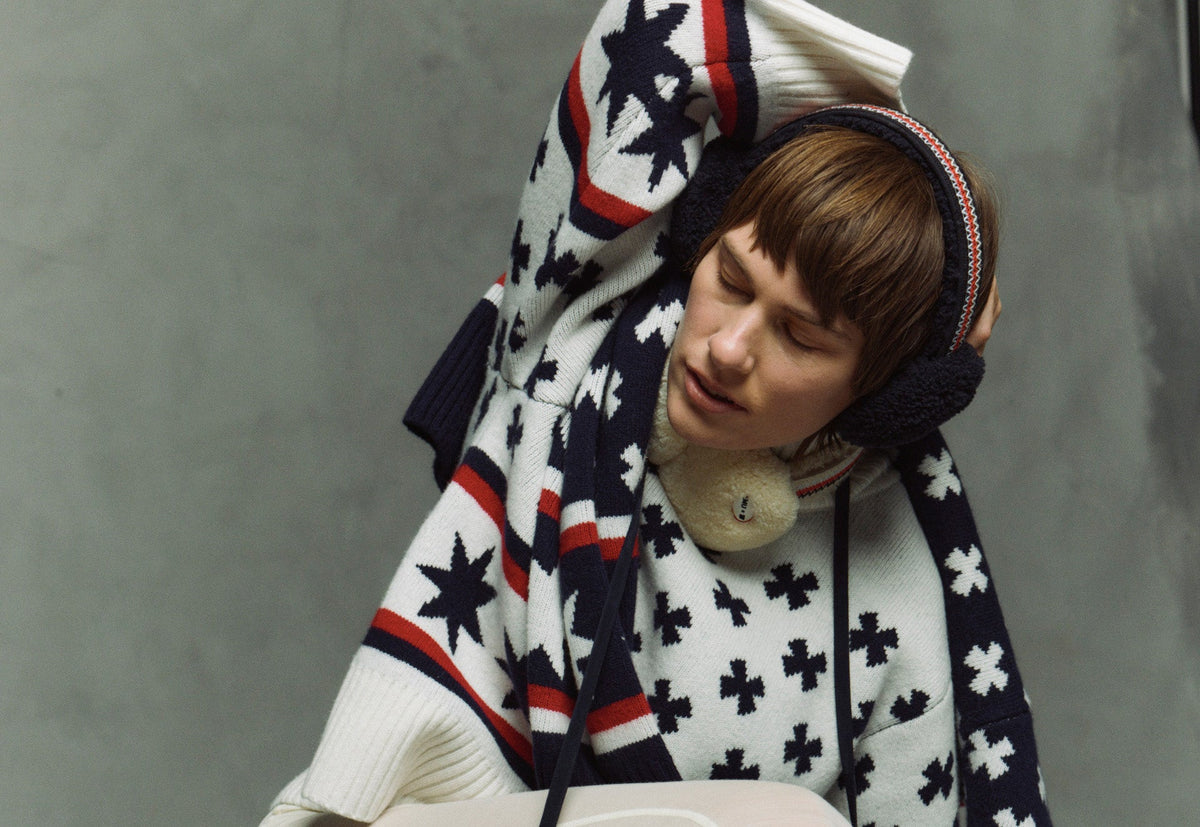 We Norwegians | FW25 | Woman wearing the Setesdal Sweater in colors "sand" against a backdrop of snowy Geilo