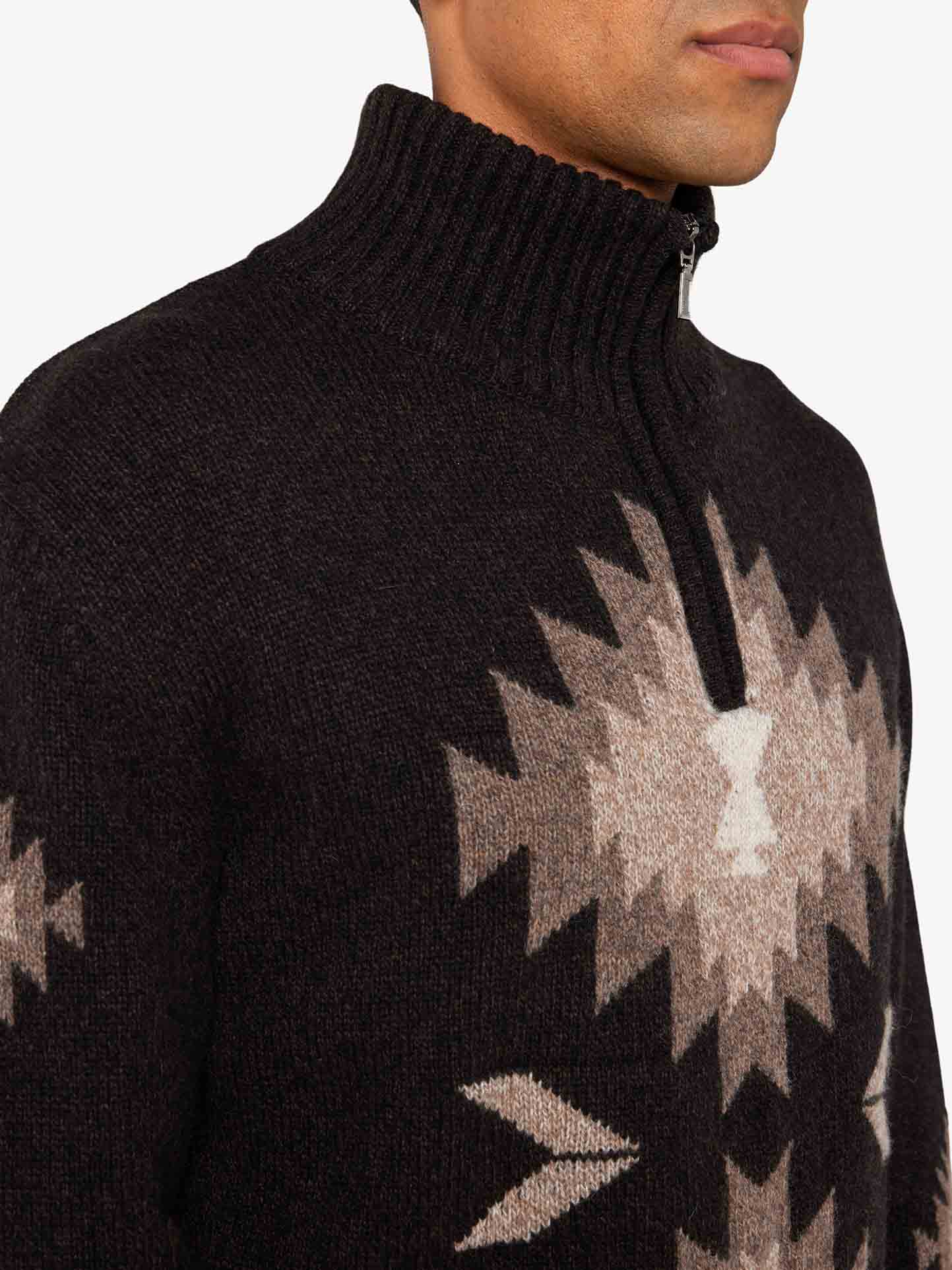 We Norwegians_FW25_Men | Model is wearing the Hovden sweater | Black in color with a striking jacquard pattern inspired by the Norwegian Sámi culture | Photograph showing neck and pattern details against a white background