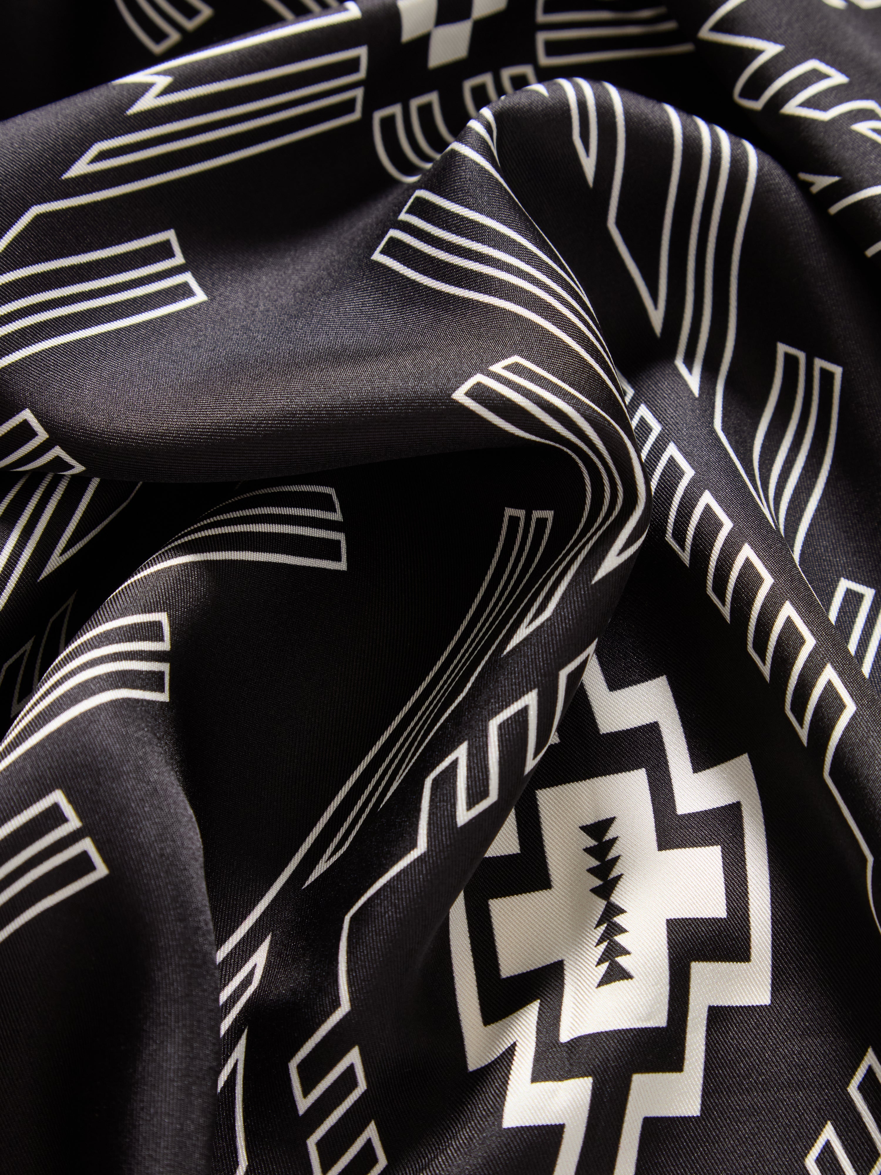 We Norwegians | FW25 | Pioneer Silk Scarf_Black | Scarf with printed motifs inspired by Indigenous American art | Photograph showing the fabric and print details
