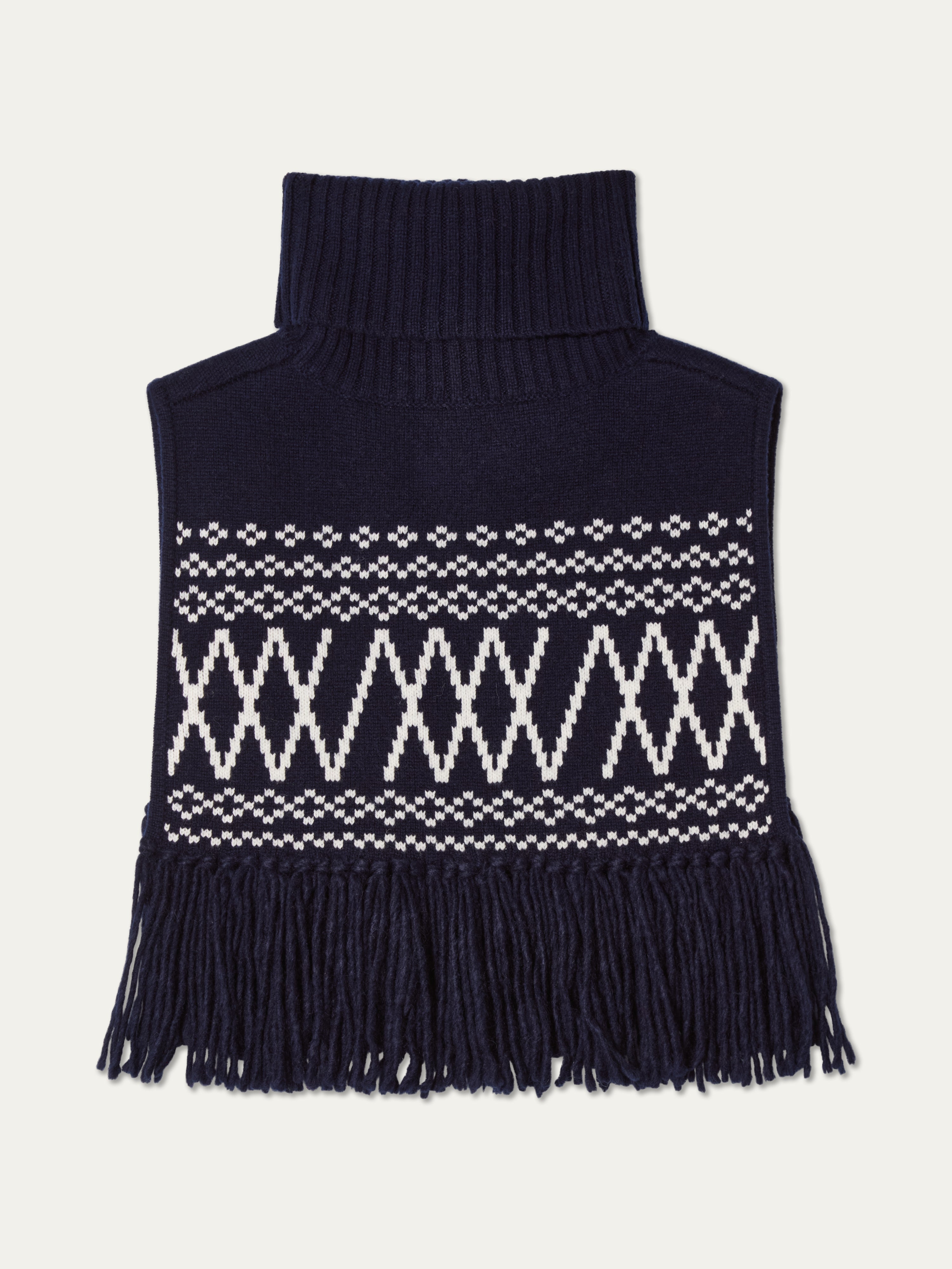 We Norwegians | FW25 | Setesdal Bib_Navy blue | A knitted bib with a turtle neck and fine fringes at the hem against an off-white background