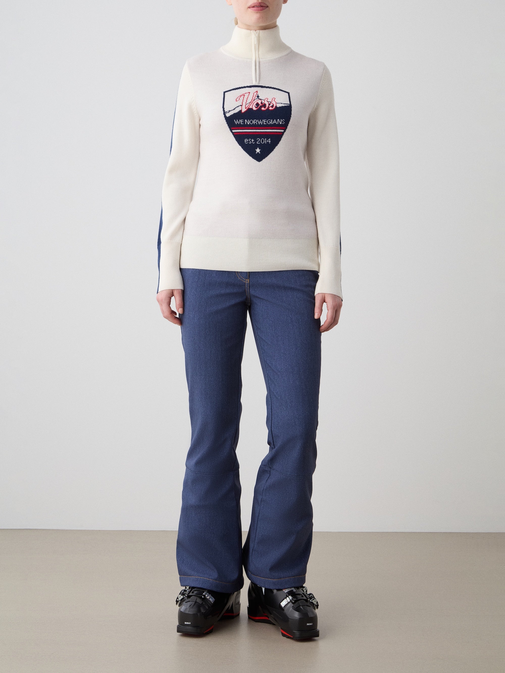 We Norwegians | FW25 | The model is wearing womens Afterski zip-up in cream which has the logo and 1/4th zipper in the front, against an off white background | Front view