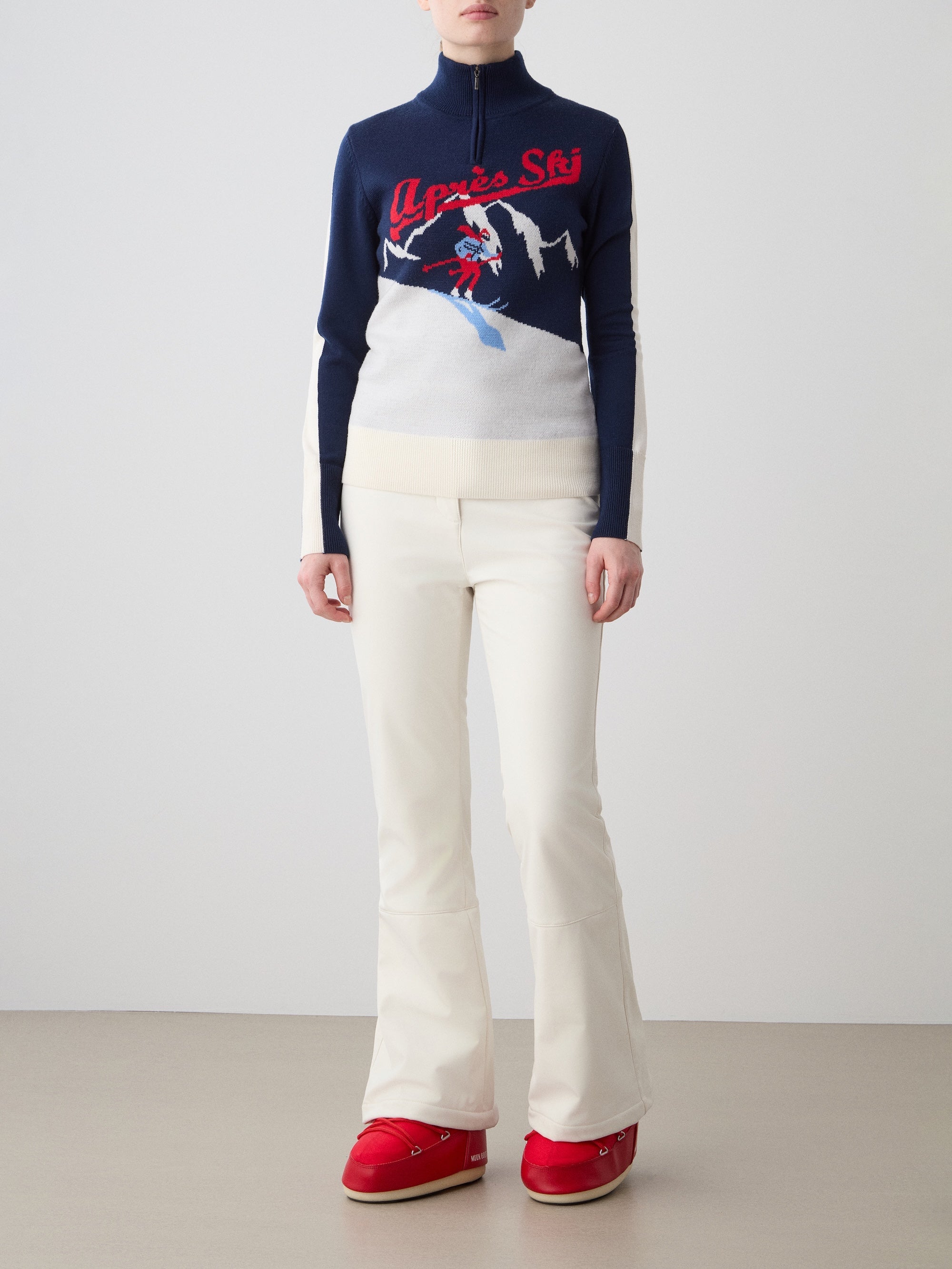 We Norwegians | FW25 | The model is wearing womens Afterski zip-up in navy blue which has the logo and 1/4th zipper in the front, against an off white background | Front view